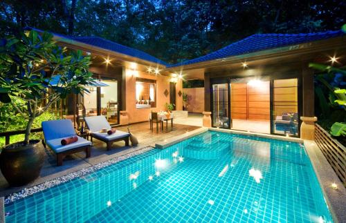 a swimming pool with two chairs and a house at Korsiri Pool Villas in Panwa Beach