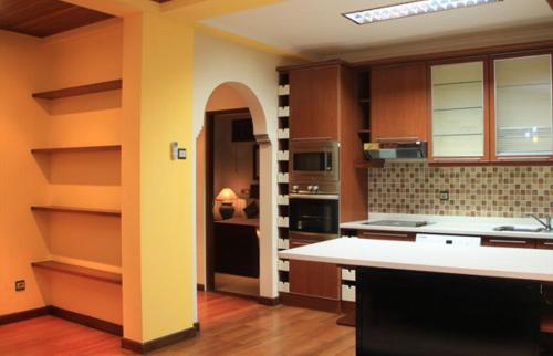 a kitchen with brown cabinets and a white counter top at Apel Villa Sanur in Sanur