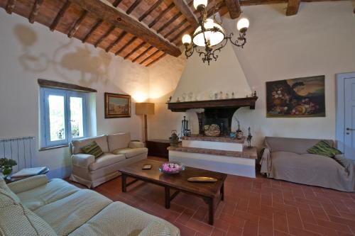 sala de estar con sofá y chimenea en Podere San Quirico, en Castelnuovo Berardenga