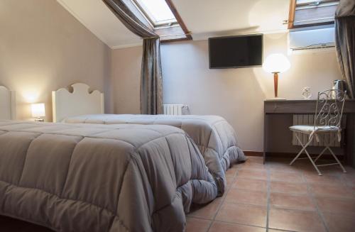 a hotel room with two beds and a television at RESIDENZA D'ORIA B&B in Foggia