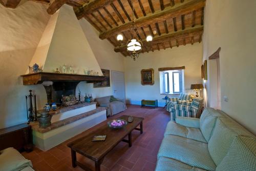 a living room with a couch and a fireplace at Podere San Quirico in Castelnuovo Berardenga