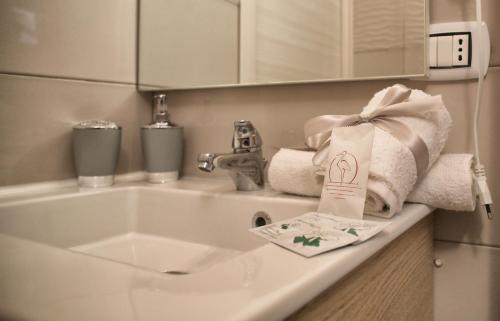 a bathroom sink with towels and a bag on it at Luxury View Apartment in Casola di Napoli