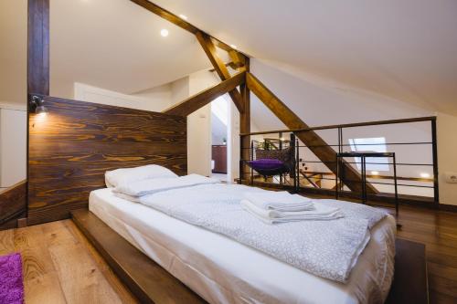 a bedroom with a large bed with a wooden wall at Apartment Lea Lux in Belgrade
