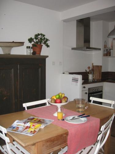 a kitchen with a table with a bowl of fruit on it at Les jardins du vivier in Combrit