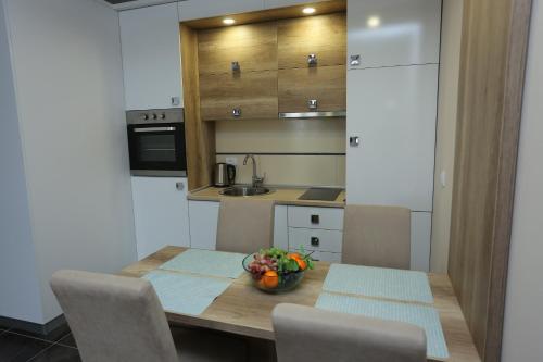 a kitchen with a table with a bowl of fruit on it at Zlatibor Hills Star Wellness & Spa in Zlatibor