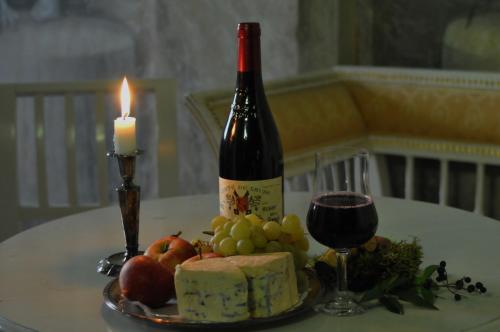 a bottle of wine and a plate of fruit and a candle at Husby Säteri in Söderköping