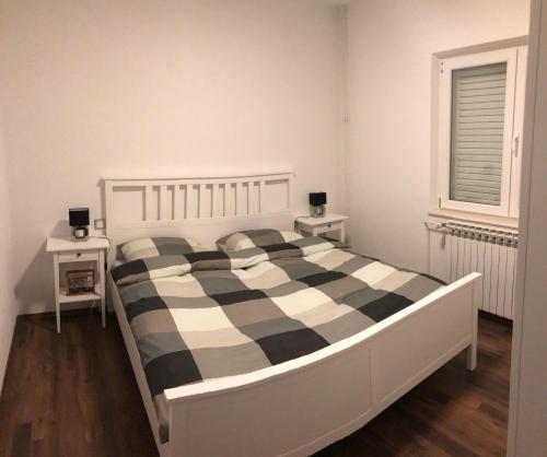 - une chambre avec un lit à damiers noir et blanc dans l'établissement Leticia, à Biograd na Moru