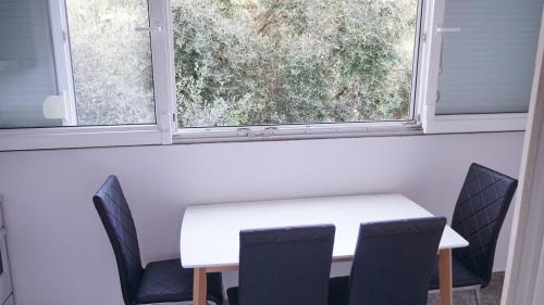 a table and chairs in a room with a window at Apartmani Abeona in Budva