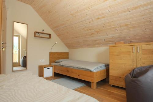 een slaapkamer met 2 bedden en een houten plafond bij Apartma - Počitniška hiša Lodi in Bohinj