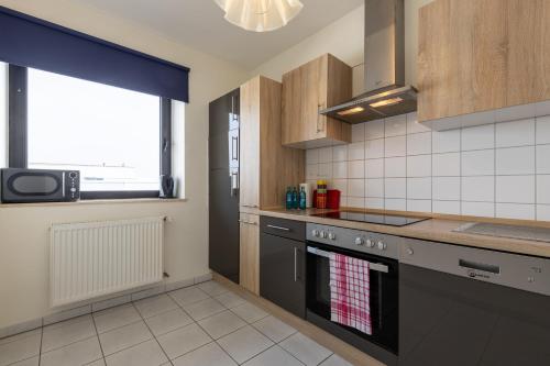 a kitchen with a stove top oven next to a window at Fly Inn Hotel Frankfurt Airport Rüsselsheim ehemals Trip Inn Hotels in Rüsselsheim