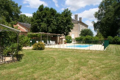 a yard with a house and a swimming pool at Le Chai Gite in Saint-Pierre-de-Côle
