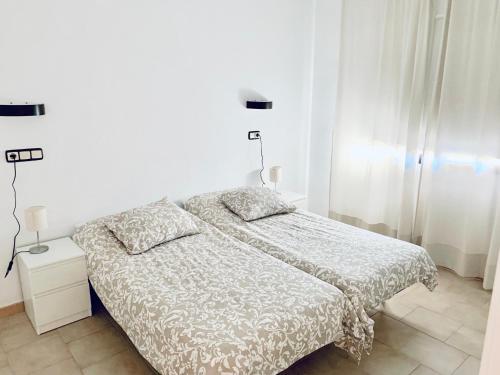 una camera bianca con un letto e due lampade di Apartamento Fuengirola R09 Edificio Ronda IV a Fuengirola