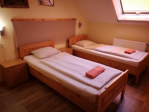two beds in a small room with a window at Hotel Amarillis in Győr