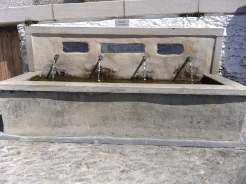 a stone fountain with water in the middle at Casa Tita María in Bubión