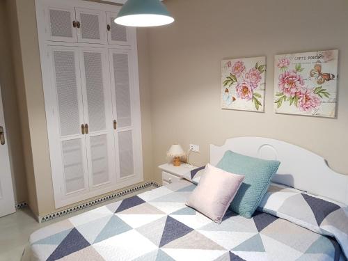 1 dormitorio con 1 cama blanca y armario blanco en Apartamento Pinar del Atlántico-La Barrosa, en Chiclana de la Frontera