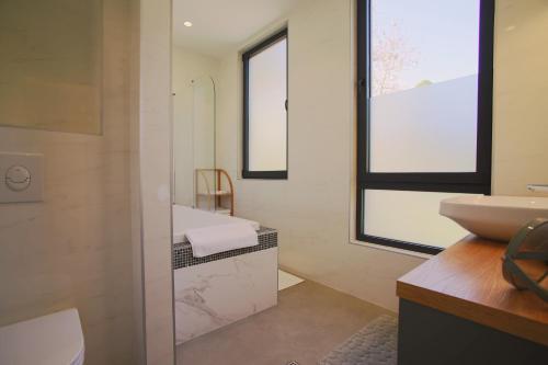 bagno con lavandino, servizi igienici e specchio di Luxury Home in Tivat Centre w/ Parking - 2Br Near Porto Montenegro a Tivat