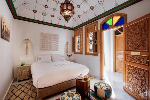 a bedroom with a white bed and a window at Emma's Riad in Marrakech