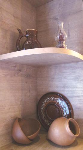 a shelf with vases and a bowl on a table at Your apartment in Old Tbilisi-Ortachala in Tbilisi City