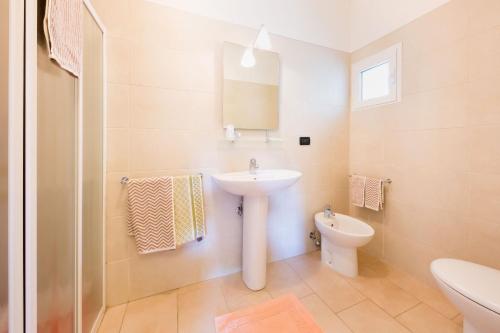 bagno bianco con lavandino e servizi igienici di Villa Maria a Caorle