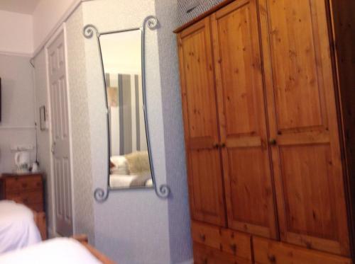 a mirror on a wall next to a bedroom at Sherwood Lodge in Skegness