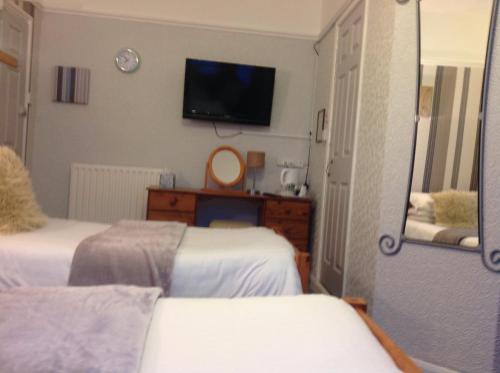 a hotel room with two beds and a mirror at Sherwood Lodge in Skegness