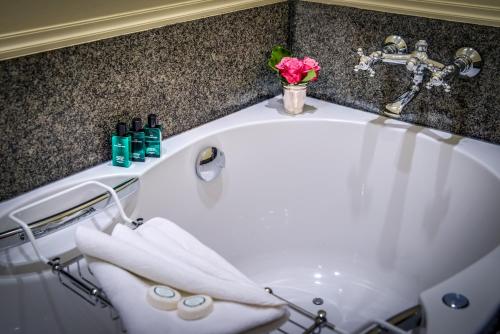 a bathroom with a bath tub with towels and a sink at B&B Exclusive Guesthouse Bonifacius in Bruges
