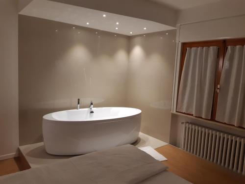 La salle de bains est pourvue d'une baignoire blanche. dans l'établissement Dolomiti Suite, à Belluno