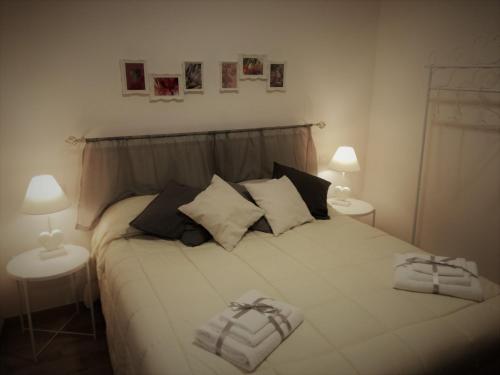 a bedroom with a white bed with two lamps at B&B Casa Lilli in Foligno