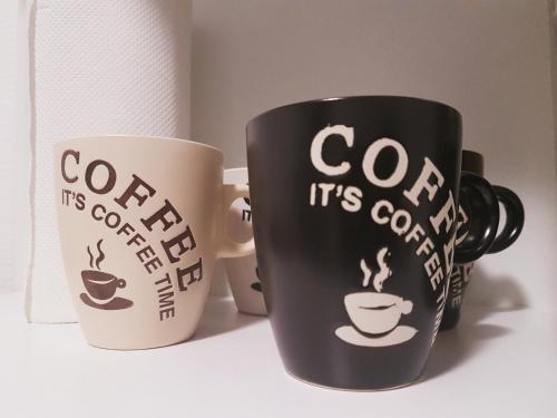 a couple of coffee cups sitting on a shelf at SW Cosy Apart - Chambly Persan Roissy in Persan