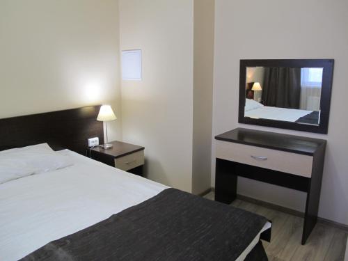 アドレルにあるApartament Shkiperskaia 9のベッドと鏡が備わるホテルルーム