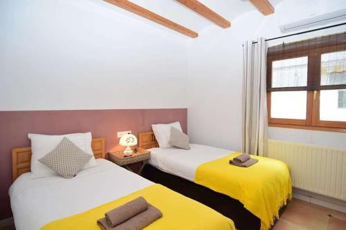 two beds in a room with yellow and white at Finca Soñada - Nudist Resort in Gayanes