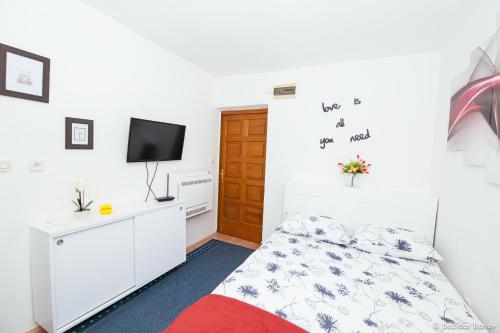 ein kleines Schlafzimmer mit einem Bett und einem TV in der Unterkunft City Apartment Tkalča - Best location in Zagreb in Zagreb