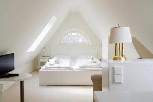 ヴェニングシュテットにあるFerienhaus "Sonnenküken"の白いベッドルーム(ベッド1台、窓付)