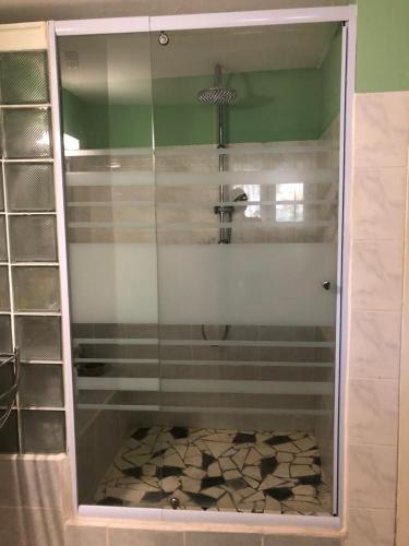 a shower with a glass door in a bathroom at La tourterelle de Neron in Le Moule