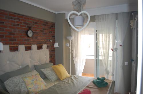 a bedroom with a bed and a brick wall at Cosy Home Boutique Apartment in Perea
