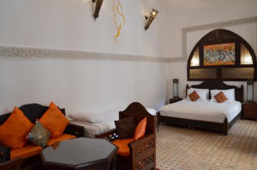 a living room with two beds and a couch at Riad Jamaï in Fès