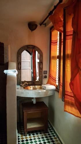 a bathroom with a sink and a mirror at Riad Jamaï in Fès