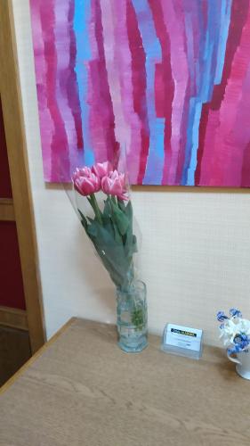 a glass vase with pink roses sitting on a table at Alabama in Kyiv