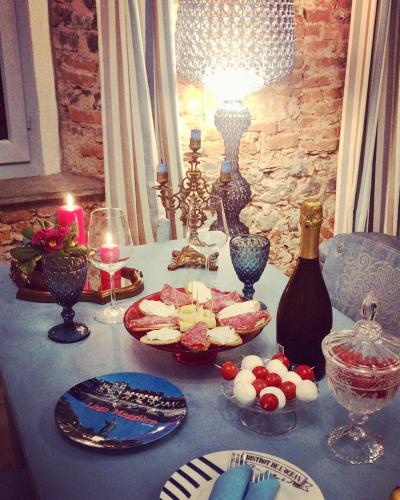 a table with a plate of food and a bottle of wine at Il Giardino Segreto Arona, Charming Apartments in Arona