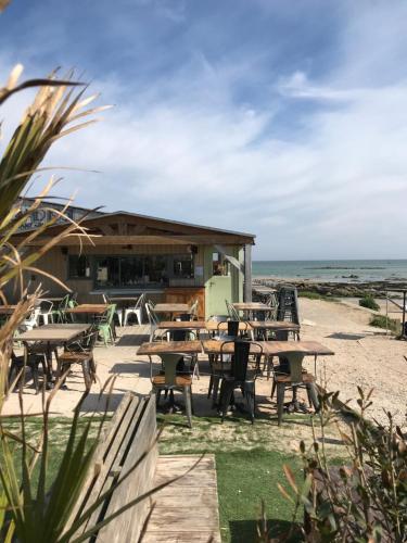 a restaurant on the beach with tables and chairs at Entre Terre et Mer in Réville