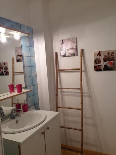 une salle de bain avec un lavabo et un miroir dans l'établissement Entre Terre et Mer, à Réville