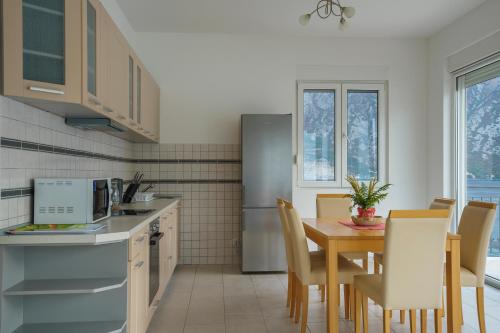 eine Küche mit einem Tisch und Stühlen sowie einem Kühlschrank in der Unterkunft Villa KOSTA in Donji Morinj