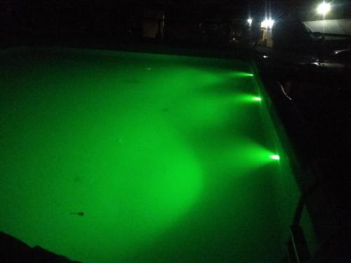 a pool with green lights on it at night at Cabañas Wairoa Haus in Villa General Belgrano