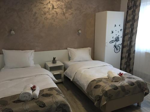 Dos camas en una habitación con toallas. en Top Style Villa, en Bragadiru