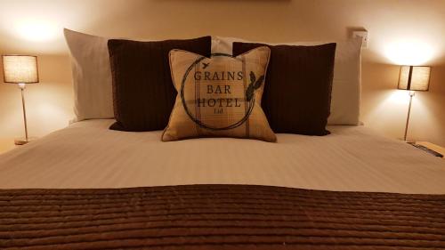 a bed with a pillow that says grains i bat hotel at Grains Bar Hotel in Oldham