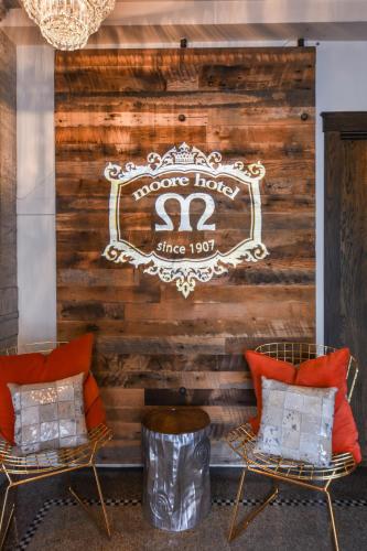 a room with two chairs and a sign on a wall at Moore Hotel in Seattle