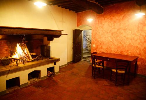 - un salon avec une cheminée, une table et une table dans l'établissement Il Papavero - Montefioralle Apartment, à Greve in Chianti