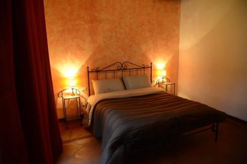 a bedroom with a bed with two lights on it at Il Papavero - Montefioralle Apartment in Greve in Chianti