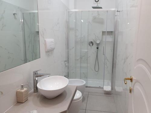 a white bathroom with a sink and a shower at Guest House Piazza Carmine in Reggio Calabria