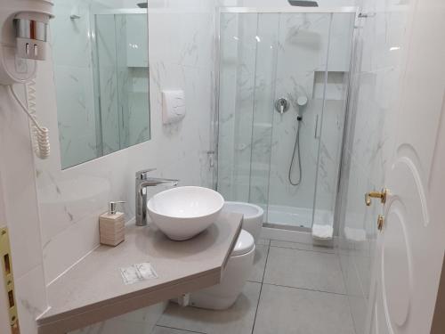 a white bathroom with a sink and a shower at Guest House Piazza Carmine in Reggio Calabria